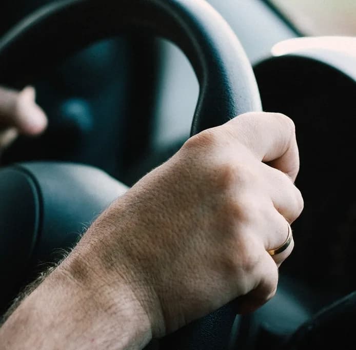 Zwei Hände am Lenkrad während der Fahrt